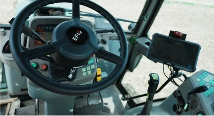 Nachgerüstetes GPS-Lenksystem mit Lenkmotor und Display in der Traktorkabine